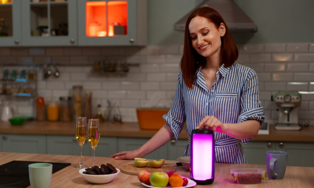 Image: A person joyfully preparing a meal with the Samsung Food App on their tablet, surrounded by fresh ingredients and kitchen utensils.